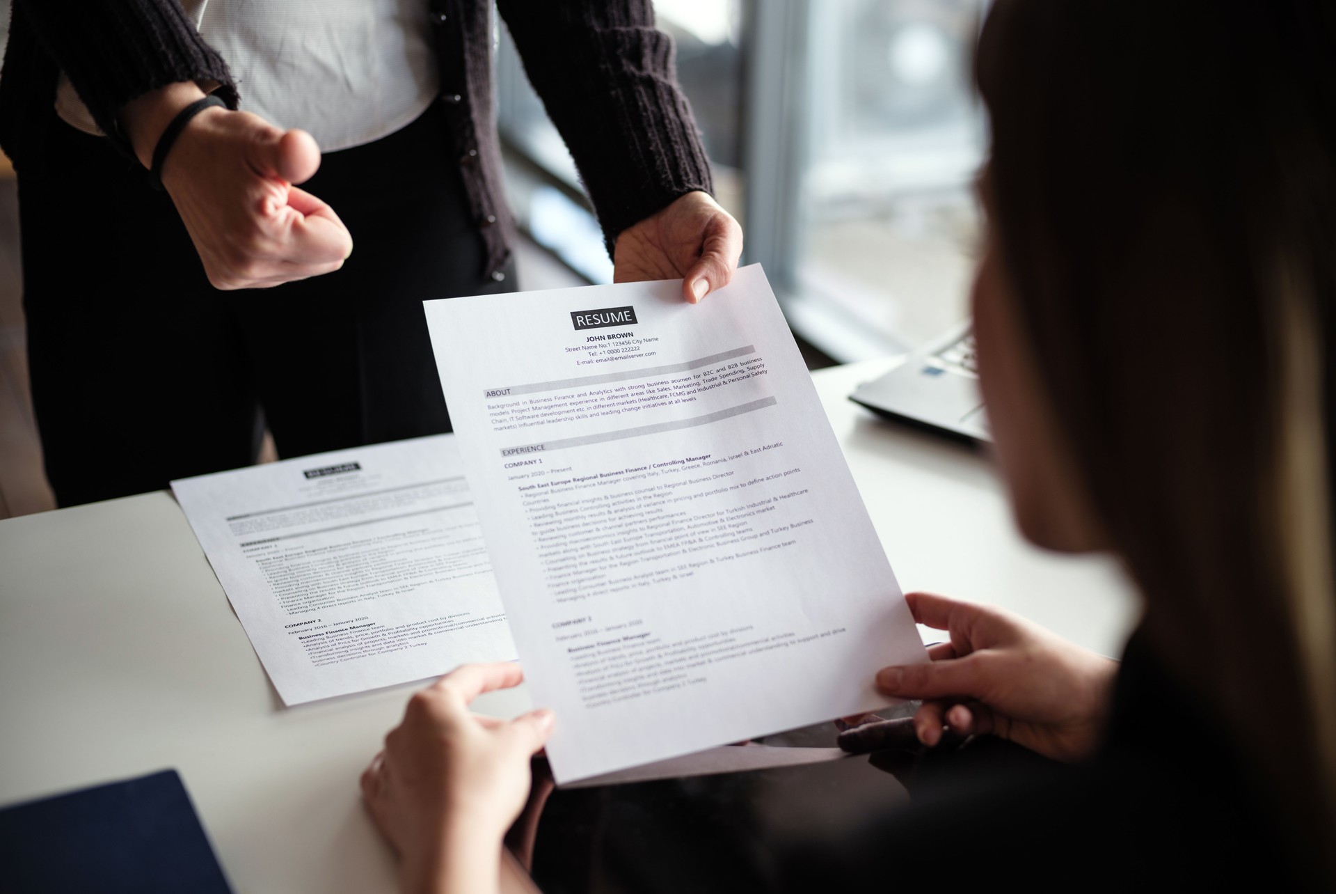 Businesswomen Discussing On The Resumes In The Office